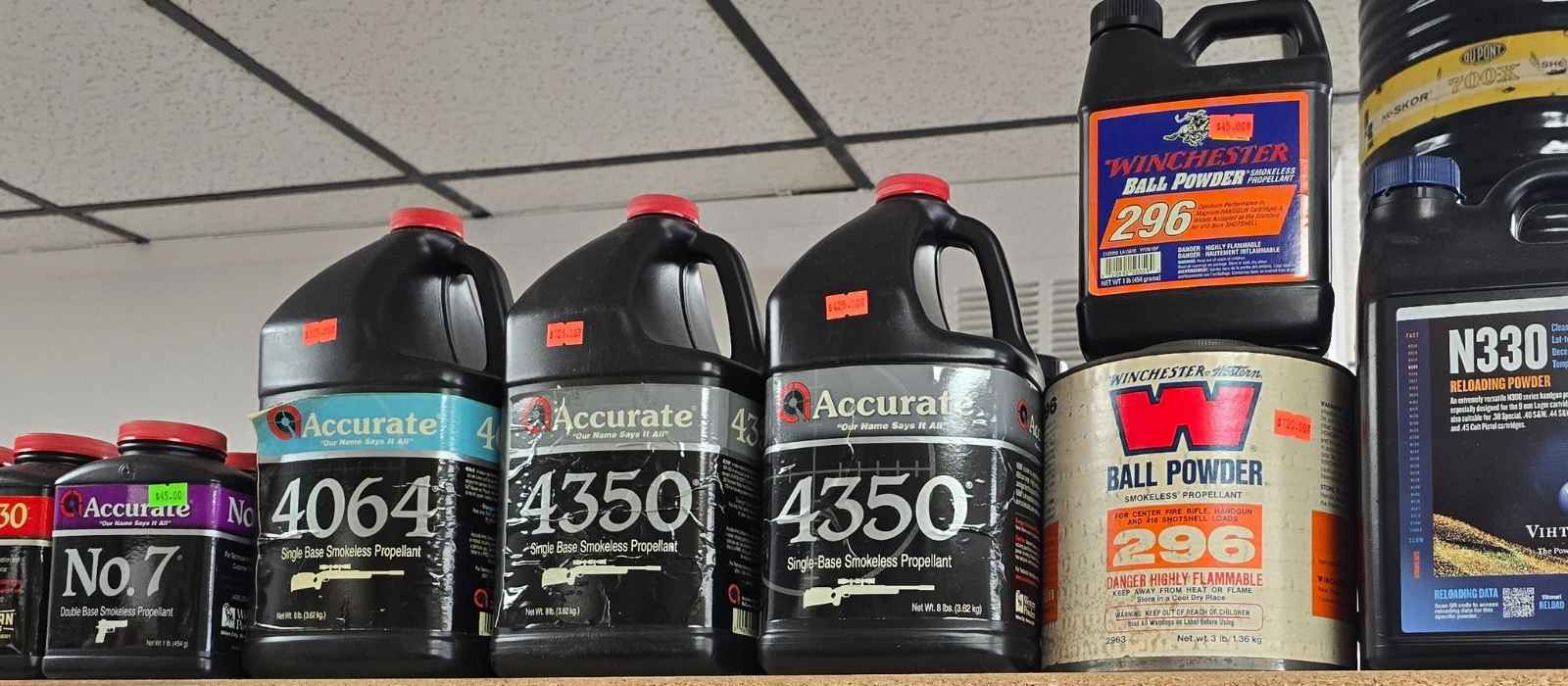 Bottles of reloading powders lined up on a shelf at Ammo Guy's Orange County ammo store.